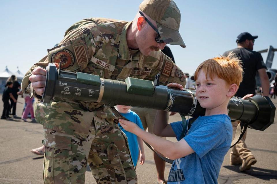 U.S. Air Force Tech Sgt. Joel Miller helps William Hoyt, 7, hold an AT4 anti-tank weapon at the California Capital Airshow on Sunday at Mather Airport.