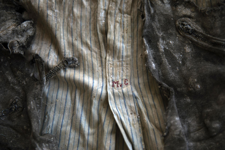 In this Thursday, March 26, 2019 photo, the clothes of a victim with monogram 'MG' embroidered into the shirt, photographed after the body was exhumed from a mass grave at the cemetery of Paterna, near Valencia, Spain, after archaeologists in Spain unearthed layers of human bones last year. DNA tests will be conducted in the hope of confirming the identities of those who disappeared eight decades ago, believed to have been executed by the forces of Gen. Francisco Franco during and after the 1936-39 Spanish Civil War.(AP Photo/Emilio Morenatti)