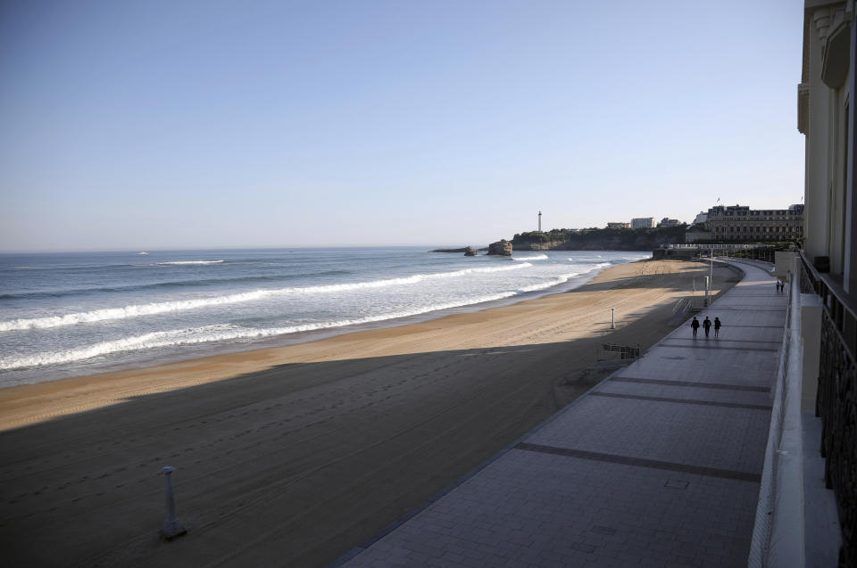 People walk along the deserted beachfront on the first day of the G-7 summit in Biarritz, France Saturday, Aug. 24, 2019. U.S. President Donald Trump and the six other leaders of the Group of Seven nations will begin meeting Saturday for three days in the southwestern French resort town of Biarritz. France holds the 2019 presidency of the G-7, which also includes Britain, Canada, Germany, Italy and Japan. (AP Photo/Markus Schreiber)