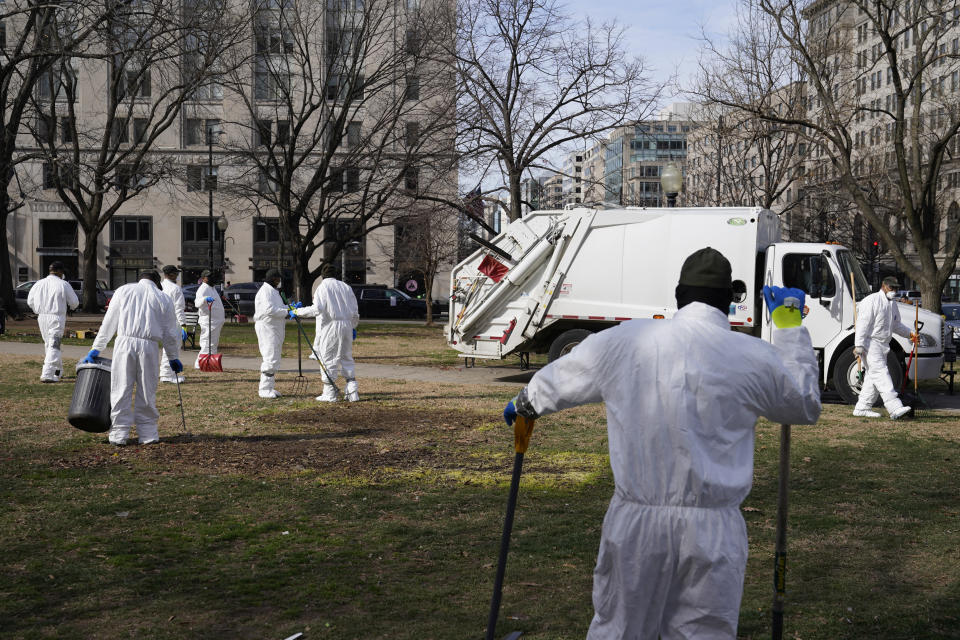 Workers clear a homeless encampment at McPherson Square in Washington, Wednesday, Feb. 15, 2023. (AP Photo/Patrick Semansky)