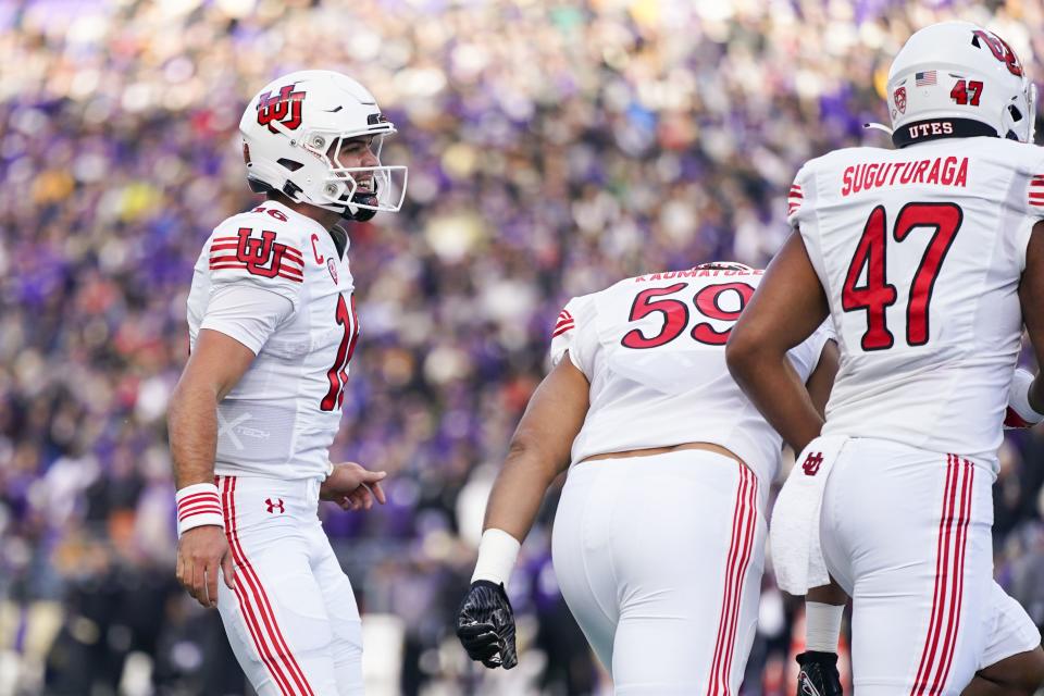 Utah quarterback Bryson Barnes (16) reacts with offensive lineman Falcon Kaumatule (59) and tight end Miki Suguturaga (47) after a touchdown against Washington during the first half of an NCAA college football game Saturday, Nov. 11, 2023, in Seattle. | Lindsey Wasson, Associated Press