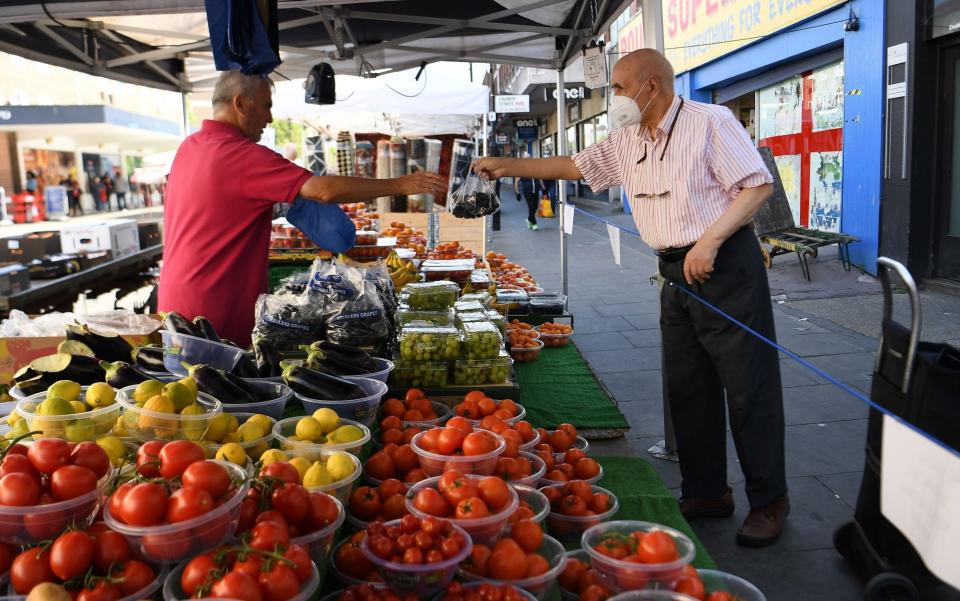 A customer at an open air market in London on the day new lockdown relaxations came into force - Shutterstock