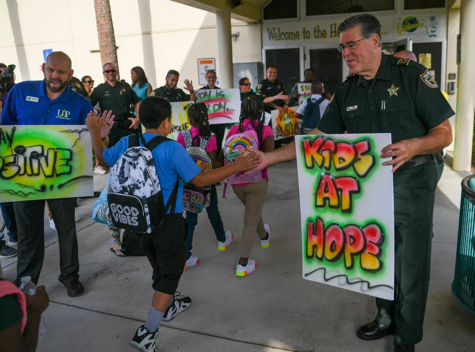 St. Lucie County Sheriff Ken Mascara (right), reaches out to students arriving for the first day of school at Chester A Moore Elementary School on Wednesday, Aug. 10, 2022, in Fort Pierce. "This is the highlight of the year coming here and seeing new students and returning students," Sheriff Mascara said. "Give them encouragement, let them know they're safe at school. It's all great."