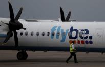 An airport worker examines a flybe aircraft before it takes off from Liverpool John Lennon Airport in Liverpool northern England.