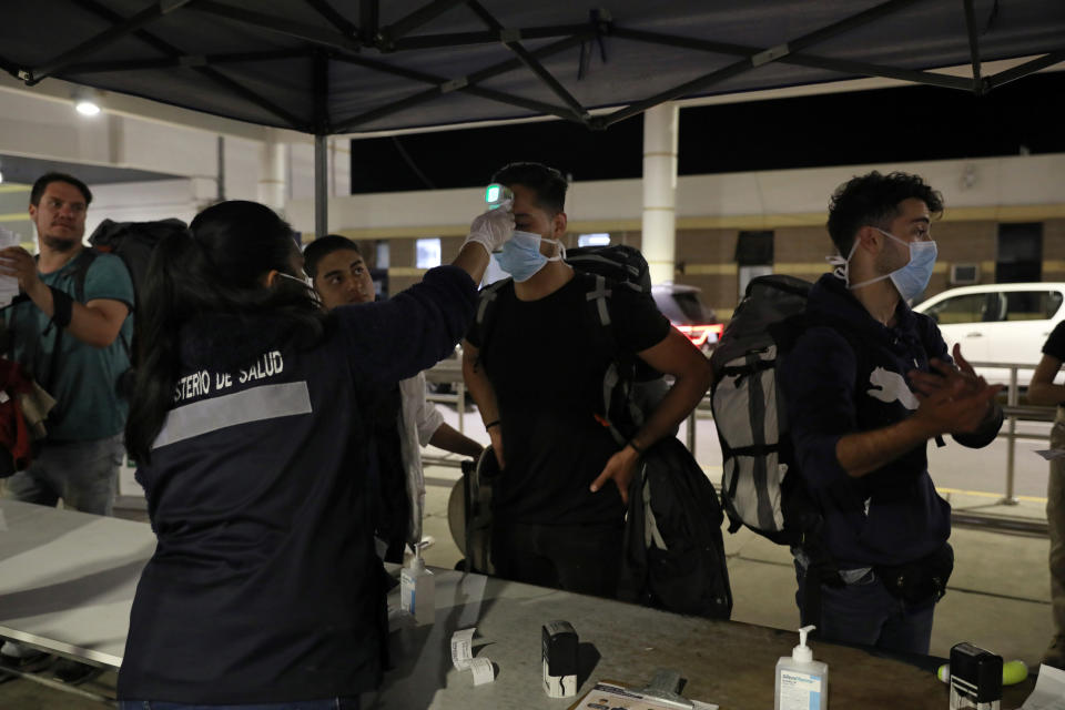 A custom worker checks person's temperature at the border between Chile and Peru, after Chile's government's announcement of the border closure in a bid to slow the spread of coronavirus disease (COVID-19), at Chacalluta check point, Arica