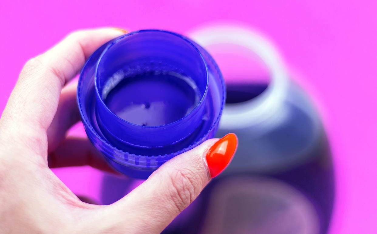 Close-up of purple laundry detergent in a measuring cup. (Getty Images)