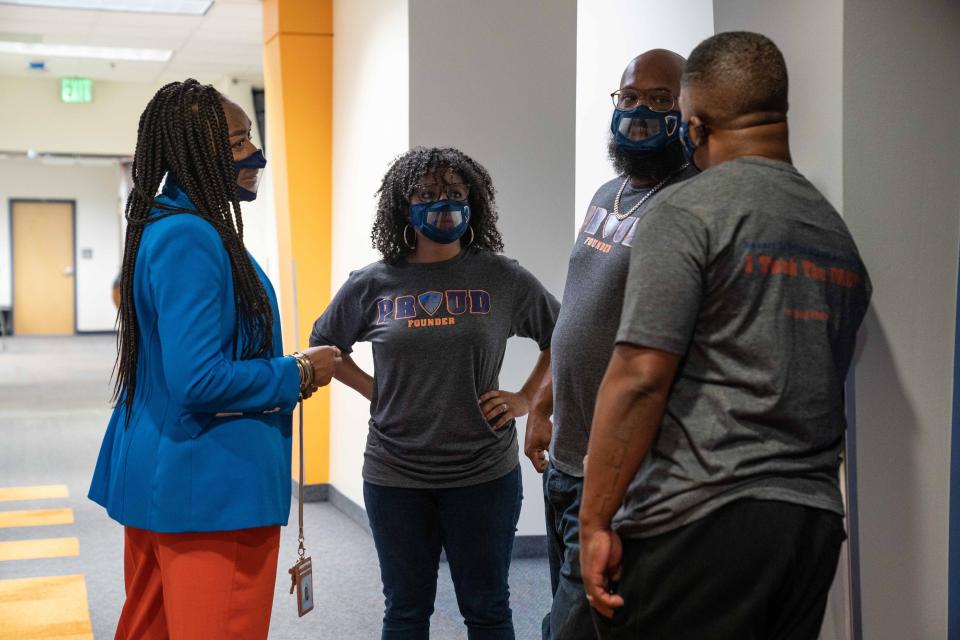 Principal Shakira Abney-Wisdom, left, Samantha Pryor, Brandon Pryor and Gabe Lindsay talk in the hallway of the Robert F. Smith STEAM Academy on opening day in Denver. The new district school is devoted to empowering and educating children of color, instead of leaving them vulnerable to disproportionate discipline and arrests that can happen in typical schools.