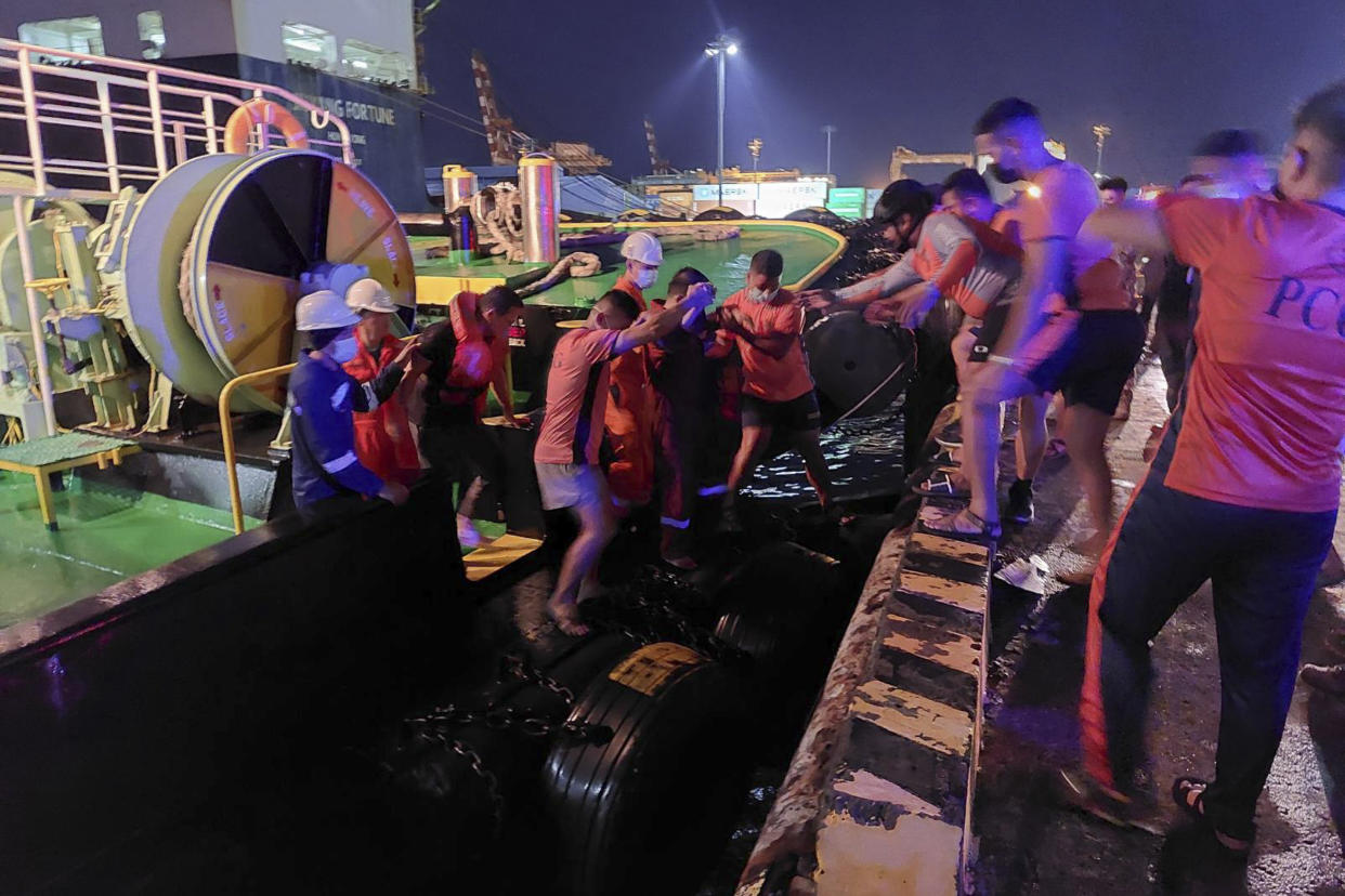 In this handout photo provided by the Philippine Coast Guard, rescuers assist people as the M/V Asia Philippines, an inter-island cargo and passenger vessel, they were riding caught fire while it was approaching Batangas port, southern Philippines on Friday. Aug. 26, 2022. A Philippine ferry carrying 82 passengers and crew caught fire as it was approaching a port south of Manila on Friday. coast guard officials said. Most of the passengers and crew have been rescued. (Philippine Coast Guard via AP)