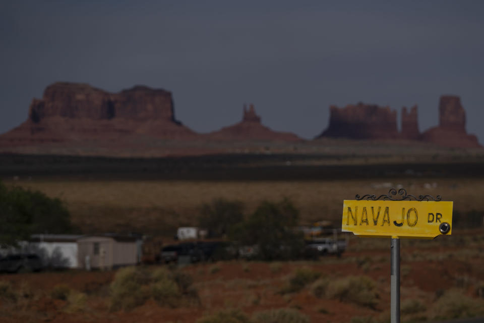 FILE - In this April 30, 2020, file photo, a sign marks Navajo Drive as Sentinel Mesa, homes and other structures in Oljato-Monument Valley, Utah on the Navajo Reservation, stand in the distance. Included in the infrastructure deal that became law last month is $2.5 billion for Native American water rights settlements. The agreements quantify individual tribes' claims to water and identify infrastructure projects to help deliver the water to residents. (AP Photo/Carolyn Kaster, File)