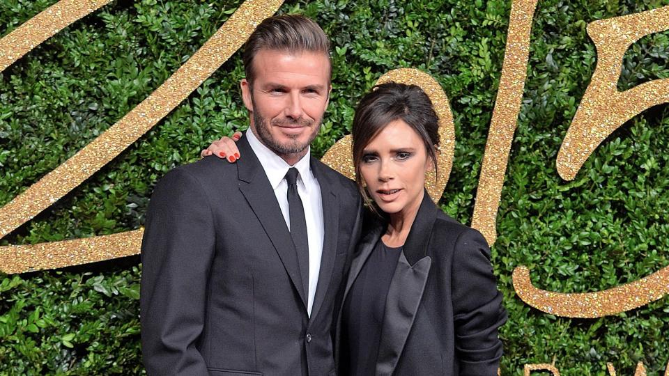 David Beckham and Victoria Beckham on red carpet in black suits