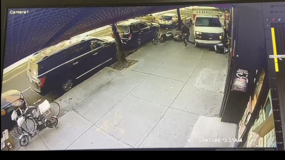 In this photo taken from security video, a man jumps out of the way as a U-Haul truck drives onto the sidewalk, Monday, Feb. 13, 2023, in the Brooklyn borough of New York. Authorities say a man driving a U-Haul truck struck and injured several pedestrians in New York City before police were able to pin the careening vehicle against a building following a mileslong pursuit through Brooklyn. (Jorge Aldaz via AP)