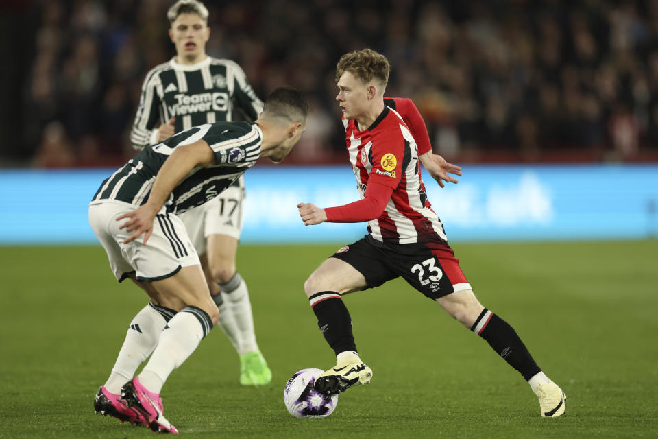 Brentford's Keane Lewis-Potter, avoids a tackle from Manchester United's Diogo Dalot during the English Premier League soccer match between Brentford and Manchester United at the Gtech Community Stadium in London, Saturday, March 30, 2024. (AP Photo/Ian Walton)