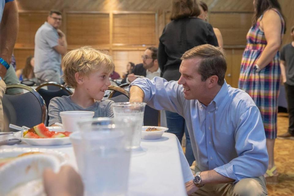 Kentucky Gov. Andy Beshear speaks with Teddy Osborne, 8, of Lexington, Ky., at the Mike Miller Memorial Marshall County Bean Dinner at the Kentucky Dam Village State Resort Park Convention Center in Gilbertsville, Ky., on Friday, Aug. 4, 2023.