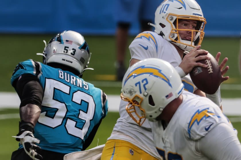 Inglewood, CA, Sunday, September 27, 2020 -Los Angeles Chargers quarterback Justin Herbert (10) delivers a pass under pressure against the Carolina Panthers at SoFi Stadium. (Robert Gauthier/ Los Angeles Times)