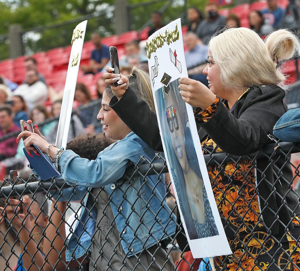 Family and friends in the stands with signs of congratulations for Quincy College graduates on Friday May, 20, 2022.