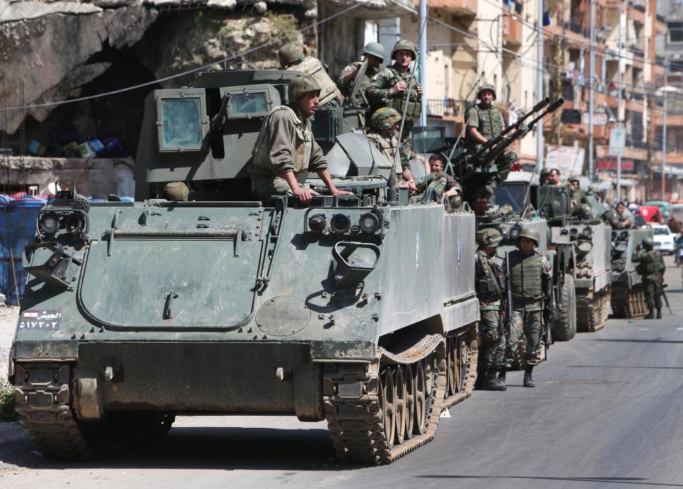 Lebanese army soldiers stand on their armored personnel carriers during their deployment in the streets of the Sunni neighborhood of Bab Tabbaneh, in the northern port city of Tripoli, Lebanon, Wednesday April, 2, 2014. In a rare day of exuberant emotion, weary residents of two warring neighborhoods greeted each other with tears and cheers as hundreds of Lebanese soldiers deployed for the first time in years throughout the area, quelling violence between them that has killed at least 200 people in three years. The Lebanese army deployment in the northern city of Tripoli is the most determined plan yet by the government to bring peace to an area that was teetering into the neighboring Syrian civil war. (AP Photo/Hussein Malla)