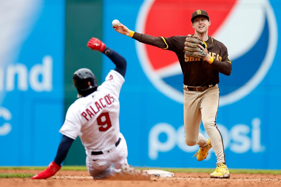 San Diego Padres' Jake Cronenworth forces out Cleveland Guardians' Richie Palacios at second base as he relays to first during the sixth inning in the first baseball game of a doubleheader, Wednesday, May 4, 2022, in Cleveland. (AP Photo/Ron Schwane)