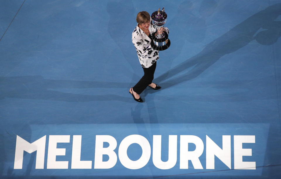 Former Australian Open champion Margaret Court holds up the women's Australian Open trophy, the Daphne Ackhurst Memorial Cup, as her 50th anniversary of her Grand Slam is celebrated at the Australian Open tennis championship in Melbourne, Australia, Monday, Jan. 27, 2020. (AP Photo/Andy Wong)