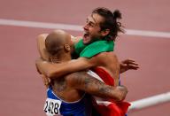 <p>Italy's Lamont Marcell Jacobs celebrates with Italian high jumper Gianmarco Tamberi after winning the men's 100m final during the Tokyo 2020 Olympic Games at the Olympic Stadium in Tokyo on August 1, 2021. (Photo by Odd ANDERSEN / AFP) (Photo by ODD ANDERSEN/AFP via Getty Images)</p> 