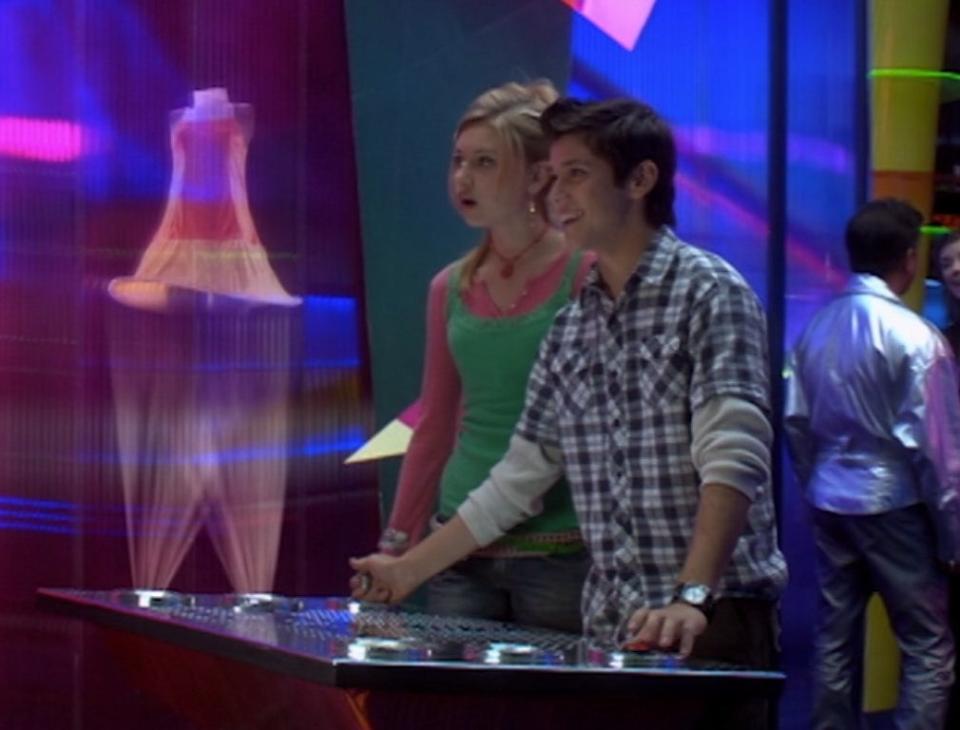 Aly Michalka and Ricky Ullman look at a hologram dress