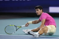 Carlos Alcaraz, of Spain, goes down attempting to return a shot from Jannik Sinner, of Italy, during the Miami Open tennis tournament, Friday, March 31, 2023, in Miami Gardens, Fla. (AP Photo/Wilfredo Lee)