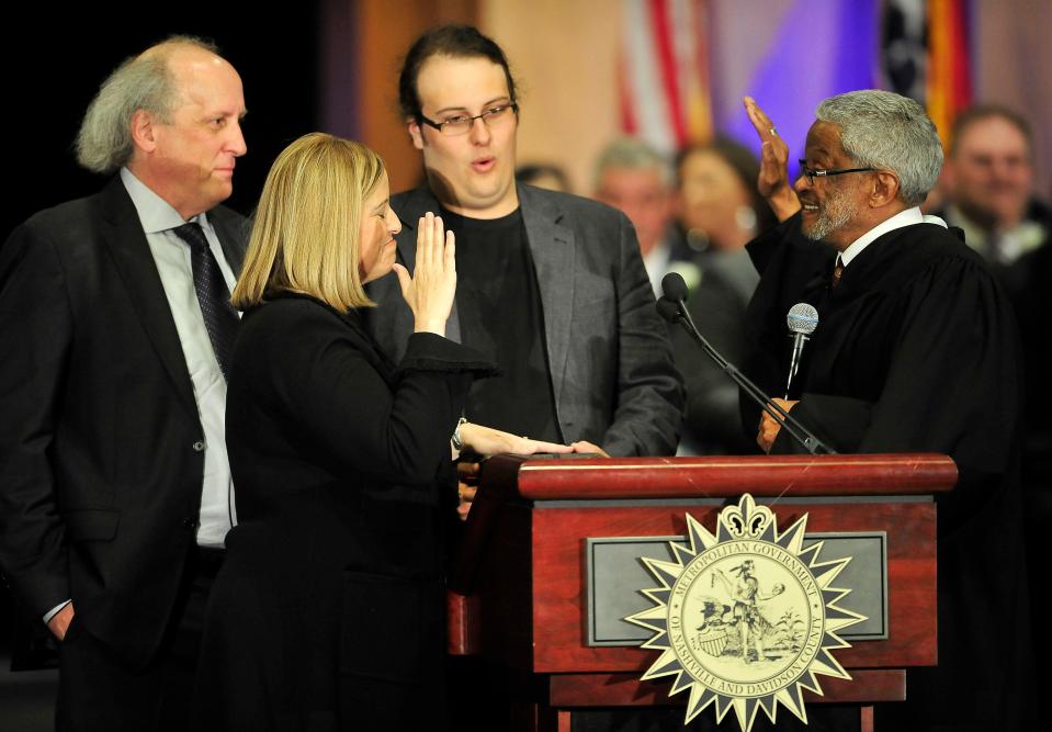 Judge Richard H. Dinkins of the Tennessee Court of Appeals, right, delivers the oath of office to Megan Barry, second from left, during an inaugural ceremony at Music City Center in Nashville.