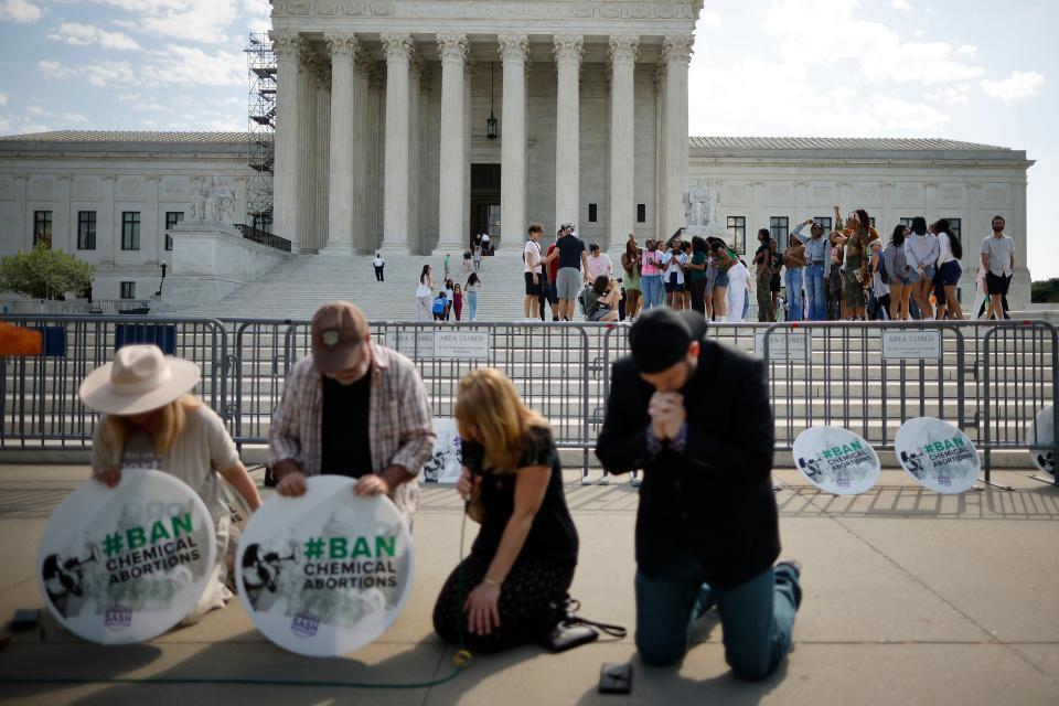 Young tourists shout their opposition to anti-abortion activists from the plaza in front of the Supreme Court on April 21, 2023.