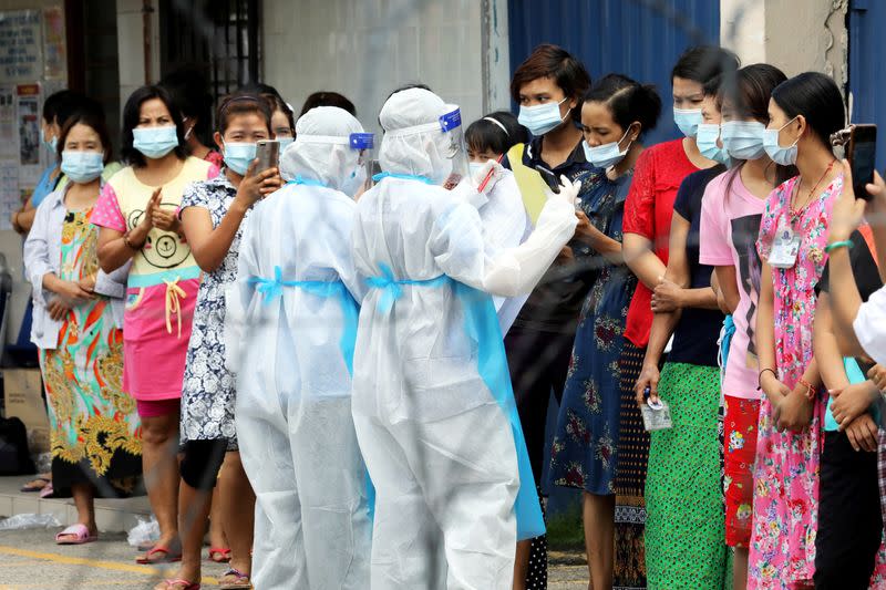 FILE PHOTO: Top Glove workers wait in line to be tested for the coronavirus disease (COVID-19) outside a hostel under enhanced lockdown in Klang