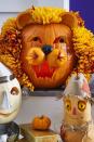 <p>No cowardly lions here: To get a fluffy lion's mane, stick faux chrysanthemums in shades of orange and yellow around its carved face. </p>