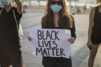 A protester holds a placard in front of the American embassy during a protest to decry the killing of George Floyd in front of the American embassy in Tel Aviv, Israel, Tuesday, June 2, 2020.(AP Photo/Ariel Schalit)