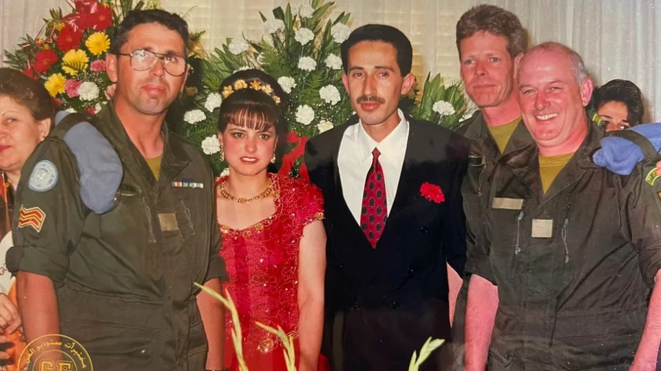 Ali and Bassima's at their wedding stood next to several soldiers