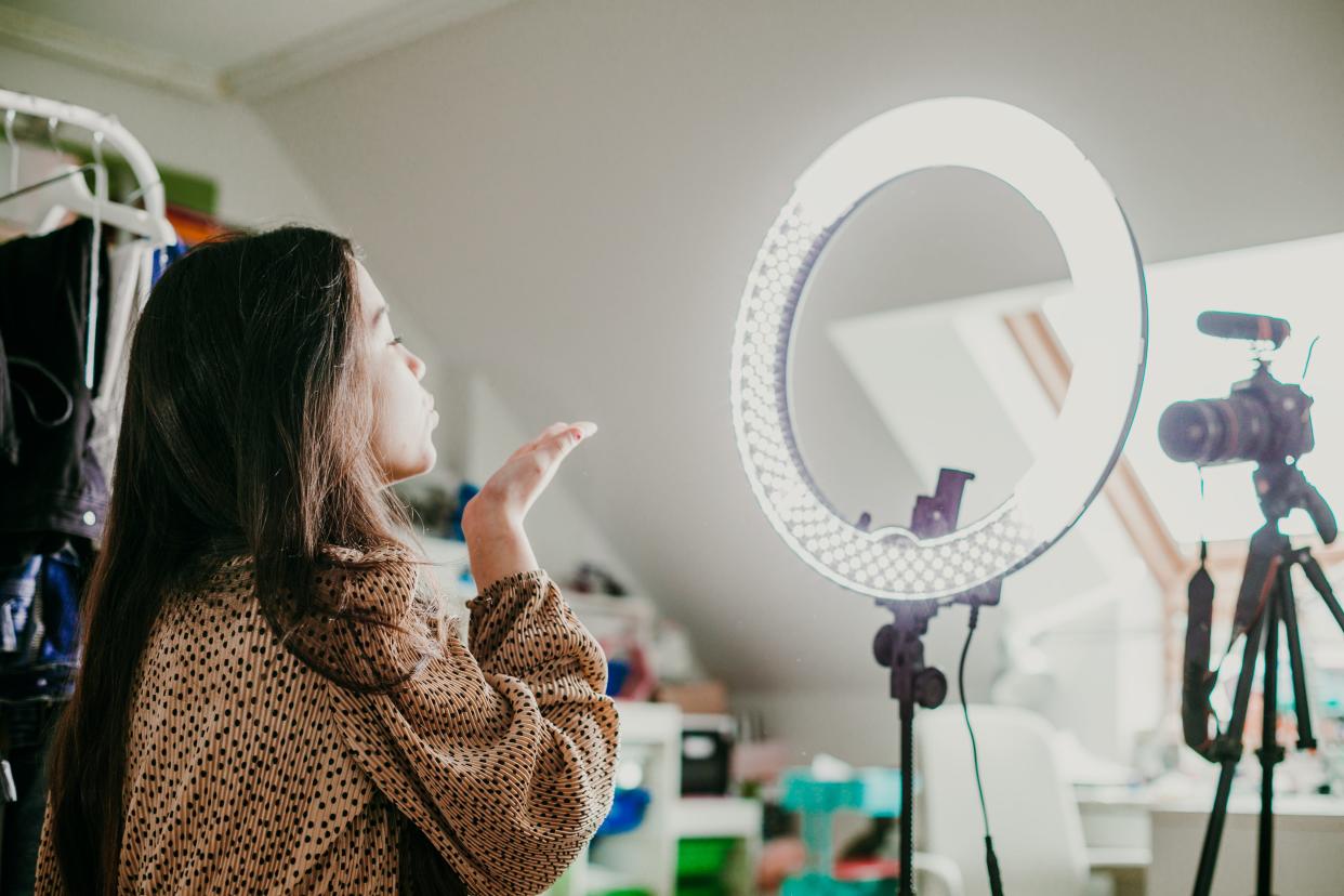 A stock image shows a social media influencer making content.