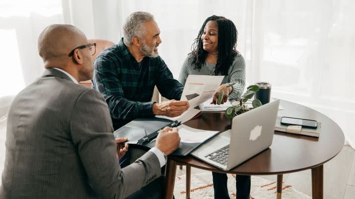 A financial advisor goes over his services and fees with a pair of prospective clients in need of retirement planning.