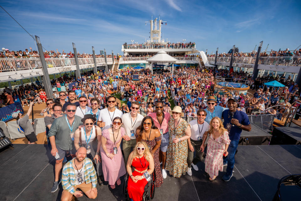 A large group of people pose together on a cruise ship.