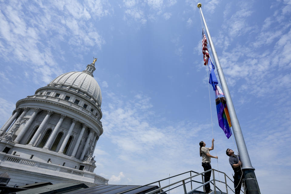 Mindy Fude and Steve Walker raise the Pride Flag at the Wisconsin State Capitol, Thursday, June 1, 2023, in Madison, Wis. (AP Photo/Morry Gash)