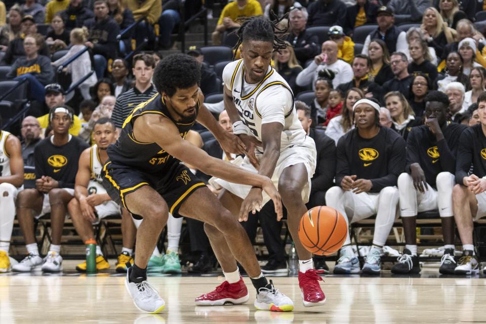 Wichita State's Harlond Beverly, left, and Missouri's Sean East II, right, battle for a loose ball during the second half of an NCAA college basketball game, Sunday, Dec. 3, 2023, in Columbia, Mo. (AP Photo/L.G. Patterson)