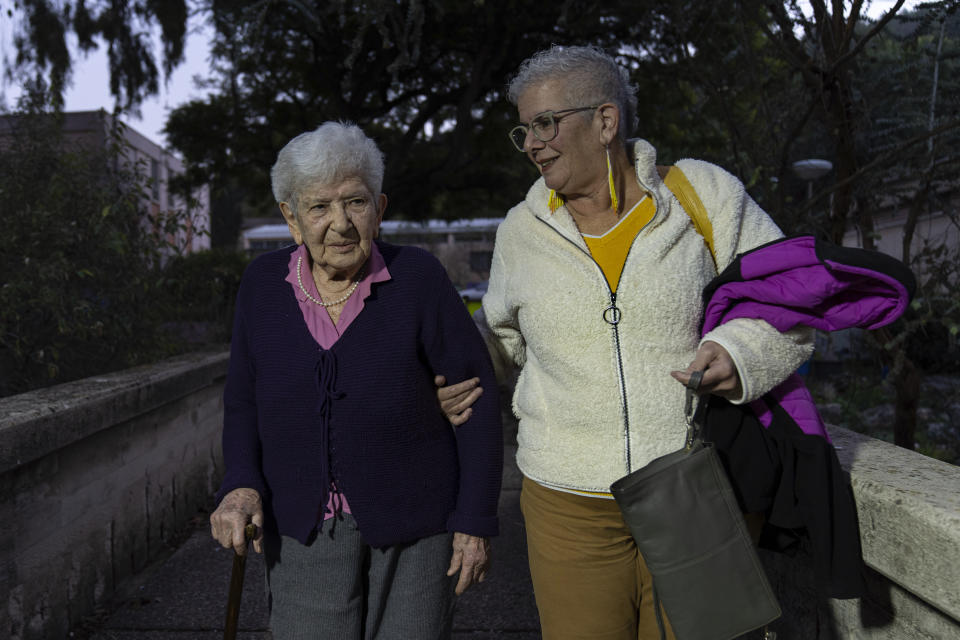 Holocaust survivor Sarah Epstein, left, and her daughter Tali arrive at a ceremony awarding the Jewish Rescuers Citation to members of the Zionist youth movement underground in Hungary during the Holocaust, at Kibbutz HaZorea, northern Israel, Tuesday, Dec. 13, 2022. Just before Nazi Germany invaded Hungary in March 1944, Jewish youth leaders in the eastern European country jumped into action: they formed an underground network that in the coming months would rescue tens of thousands of fellow Jews from the gas chambers. (AP Photo/Tsafrir Abayov)