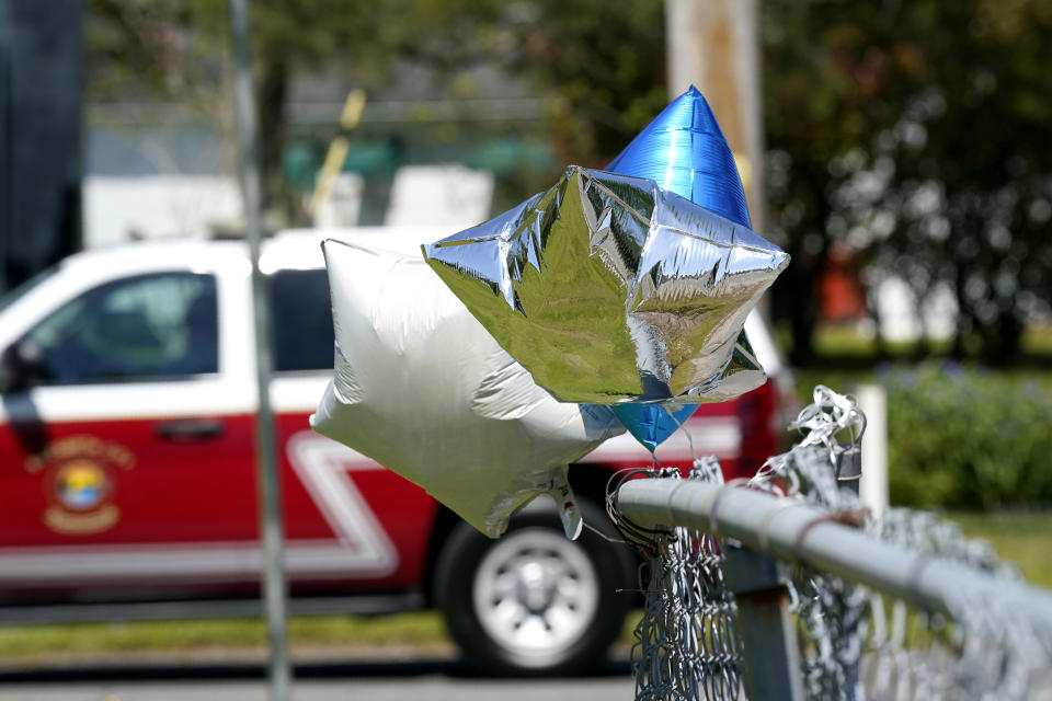 Balloons are seen tied to a fence in Elizabeth City, N.C., Thursday, April 22, 2021 at the scene where a North Carolina deputy shot and killed a Black man while executing a search warrant on Wednesday, authorities said. (AP Photo/Gerry Broome)