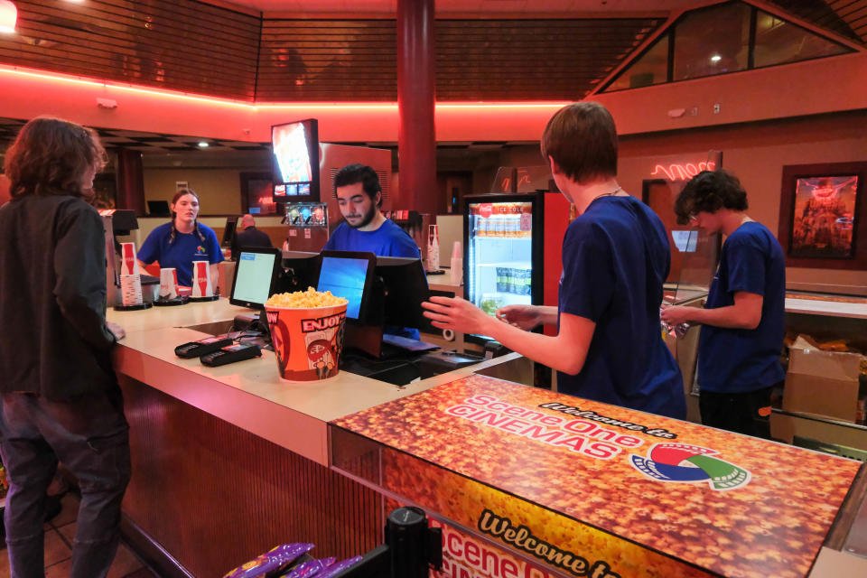 Employees of the newly opened Scene One Westgate Mall Cinemas serve a customer Wednesday at the grand opening of Amarillo's newest theater.