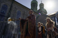 Fr. Mykola Ivanov, with an incense burner, leads members of his congregation in the procession of the Holy Shroud on Good Friday at Transfiguration Of Our Lord Ukrainian Catholic Church, in Shamokin, Pa., Friday, April 15, 2022. The Holy Shroud is taken outside around the church to symbolize the funeral procession of Christ to the grave. The Holy Shroud is a cloth depicting the Savior lying in the tomb. (AP Photo/Carolyn Kaster)