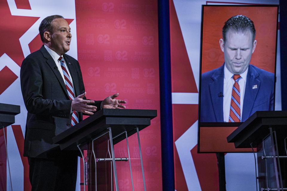 Andrew Giuliani, right, son of former New York City Mayor Rudy Giuliani, listens as Suffolk County Congressman Lee Zeldin, left, speaks during New York's Republican gubernatorial debate at the studios of CBS2 TV, Monday June 13, 2022, in New York. Giuliani participated via virtual broadcast after he was blocked from the studios for not meeting vaccine requirements. (AP Photo/Bebeto Matthews)
