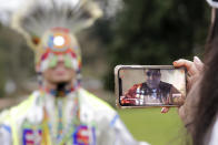 In this photo taken Saturday, April 4, 2020, moderator Whitney Rencountre, a Crow Creek Dakota tribal member, is seen on a screen from Rapid City, S.D., as he talks with Wakiyan Cuny, a Dakota and Lakota tribal member, during a live streamed powwow, in Puyallup, Wash. The largest powwows in the country have been canceled or postponed amid the spread of the coronavirus. Tribal members have found a new outlet online with the Social Distance Powwow. They're sharing videos of colorful displays of culture and tradition that are at their essence meant to uplift people during difficult times. (AP Photo/Elaine Thompson)