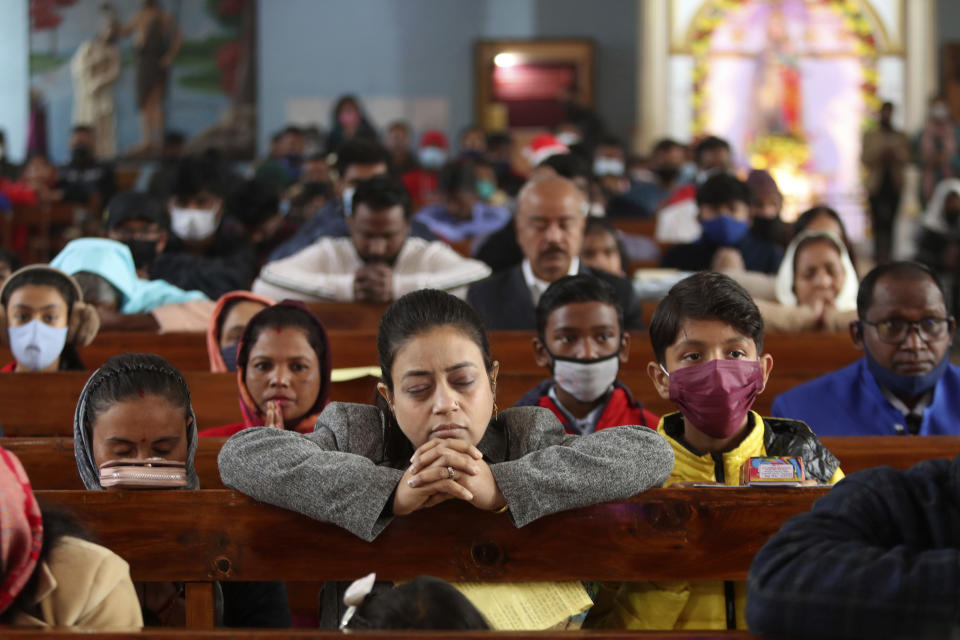 Indian Christians, some wearing face masks as a precaution against the COVID-19, attend a Christmas mass at Saint Mary's Garrison church in Jammu, India, Saturday, Dec. 25, 2021. (AP Photo/Channi Anand)