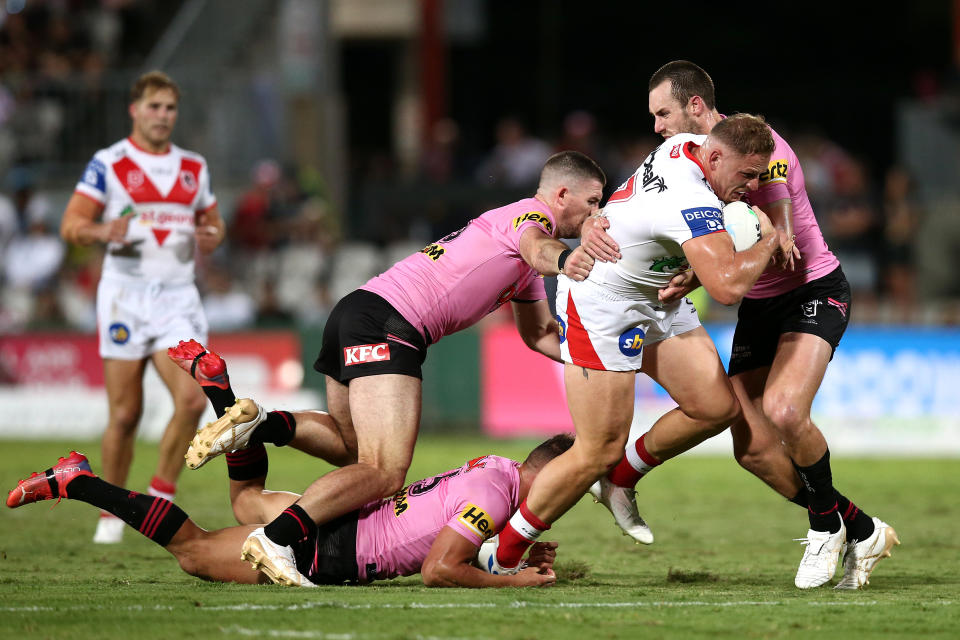 Pictured here, Dragons forward George Burgess being tackled during the round two NRL match against the Penrith Panthers, 