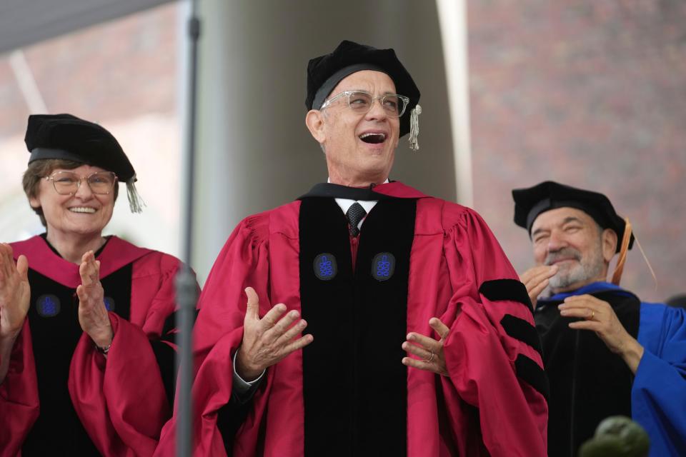 May 25, 2023 : Actor Tom Hanks, center, reacts as he is presented with an honorary degree of Doctor of Arts as Biochemist Katalin Kariko, left, looks on during Harvard University commencement exercises on the school's campus in Cambridge, Mass. Kariko was awarded an honorary degree of Doctor of Science.