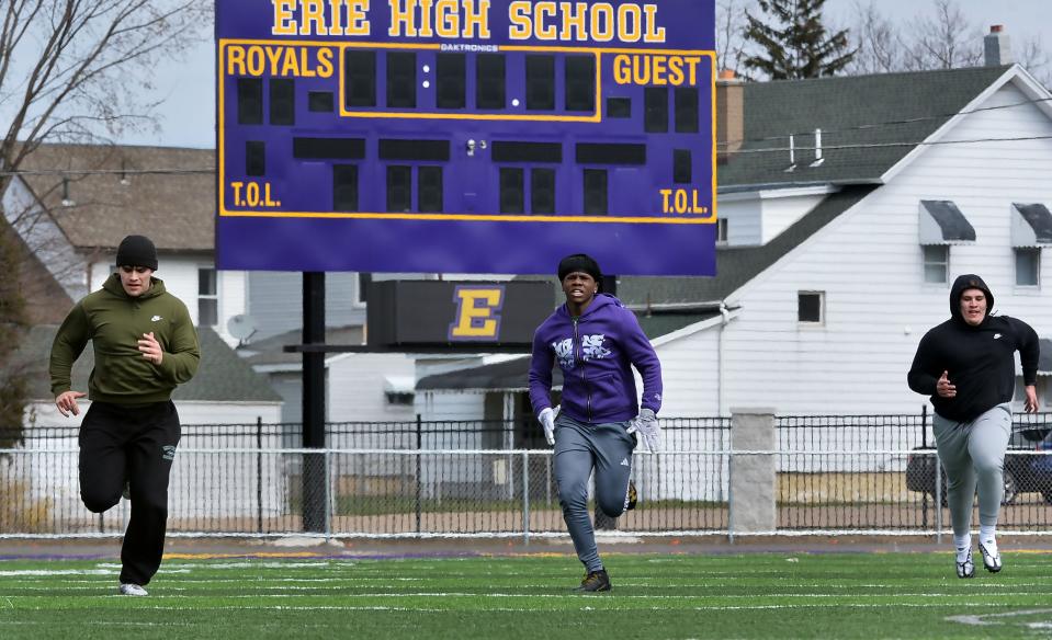 McDowell High School junior Francisco Torres, 17, left, Erie High freshman Iyzaren Woodard, 14, and Erie High junior Isaiah Shatto, 17, run 100-yard sprints at Biletnikoff Field in Erie on March 29.