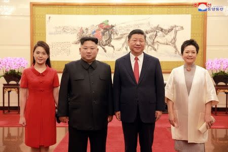 Chinese President Xi Jinping and his wife Peng Liyuan, pose for a photo with North Korean leader Kim Jong Un and his wife Ri Sol Ju during their visit in Beijing, China, in this undated photo released June 20, 2018 by North Korea's Korean Central News Agency. KCNA via REUTERS