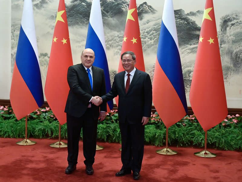 Russian Prime Minister Mikhail Mishustin and Chinese Premier Li Qiang attend a meeting in Beijing