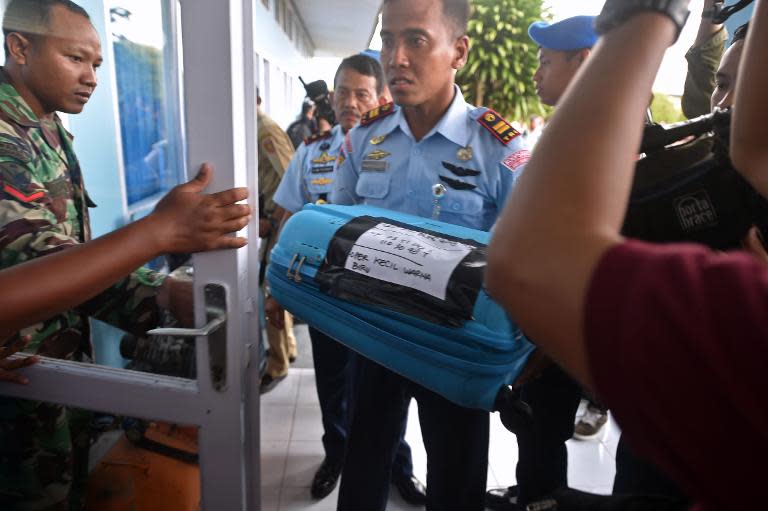 A member of the Indonesian air force carries an item retrieved from the Java Sea during search and rescue operations for the missing AirAsia flight QZ8501, in Pangkalan Bun, Central Kalimantan, on December 30, 2014