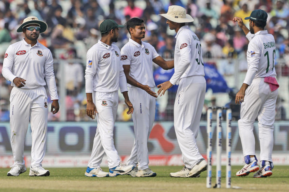 Bangladesh's Taijul Islam, center, is congratulated by teammates after he took the wicket of India's Ajinkya Rahane during the second day of the second test cricket match between India and Bangladesh, in Kolkata, India, Saturday, Nov. 23, 2019. (AP Photo/Bikas Das)